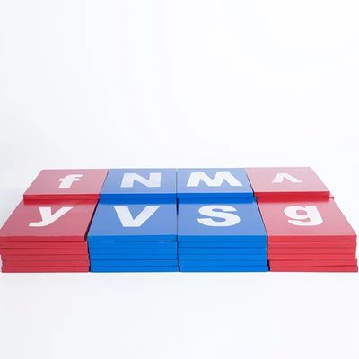 Bebê que aprende placas de seguimento do alfabeto de madeira de Montessori